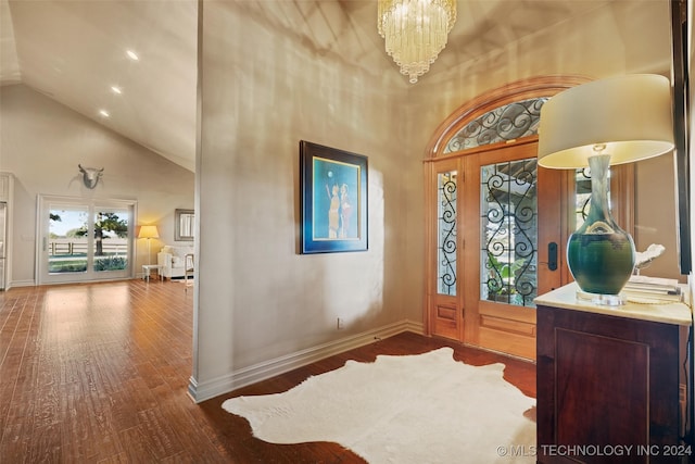 foyer with high vaulted ceiling, wood-type flooring, and a notable chandelier