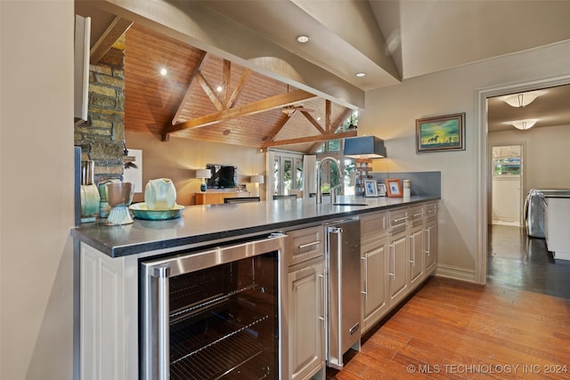 kitchen with beverage cooler, wood ceiling, sink, lofted ceiling with beams, and light wood-type flooring