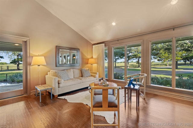 living room with vaulted ceiling, hardwood / wood-style flooring, and a healthy amount of sunlight