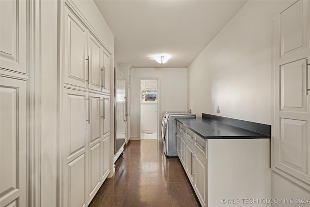 kitchen with independent washer and dryer, high end refrigerator, and white cabinets