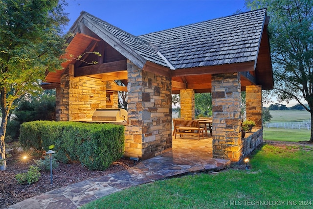 exterior space with a yard, an outdoor kitchen, and a patio area