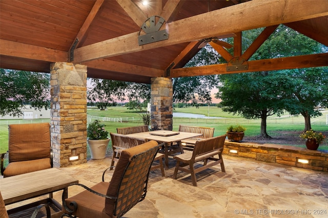 patio terrace at dusk with a lawn, a rural view, and a gazebo