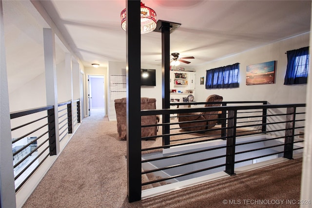 corridor with an upstairs landing and carpet