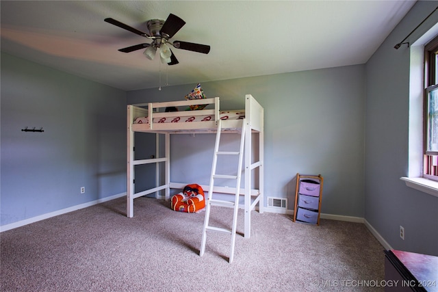 unfurnished bedroom with baseboards, a ceiling fan, visible vents, and carpet floors