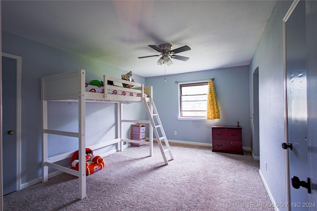 carpeted bedroom featuring a textured ceiling, baseboards, and a ceiling fan