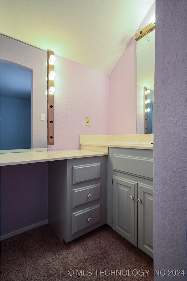 bathroom with lofted ceiling and vanity