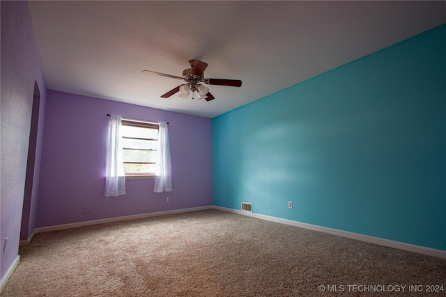 carpeted spare room with ceiling fan