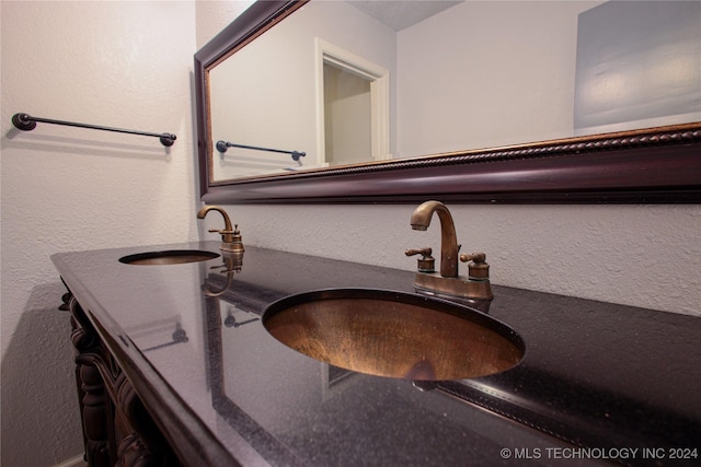 room details with vanity and a textured wall