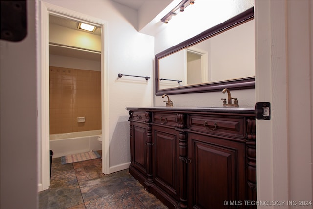 full bathroom with toilet, vanity, and tiled shower / bath combo