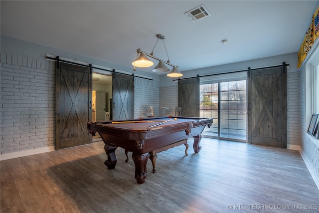 rec room with wood-type flooring, brick wall, billiards, and a barn door