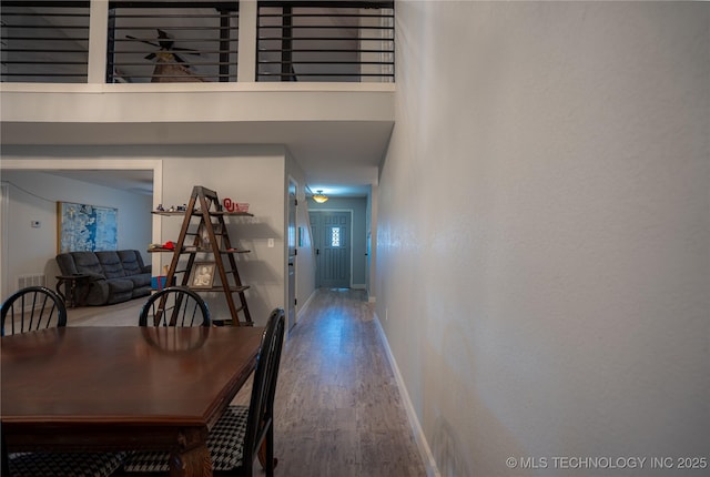 hallway with a towering ceiling and hardwood / wood-style flooring