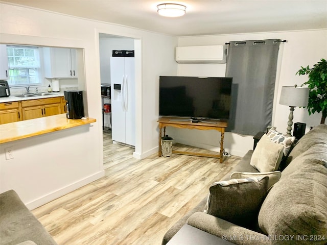 living room with light hardwood / wood-style flooring, sink, and a wall unit AC