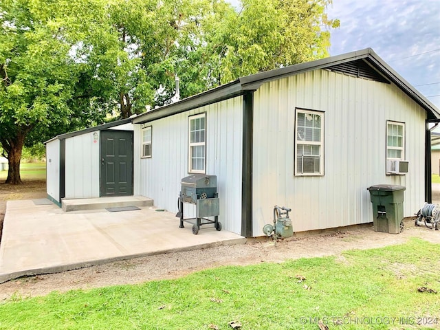 view of outbuilding with cooling unit and a yard