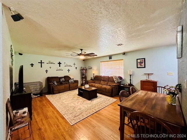 living room with wood-type flooring, a textured ceiling, and ceiling fan