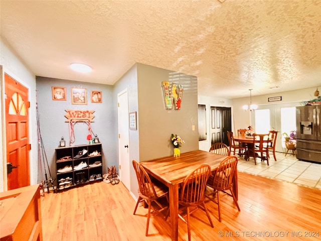 dining space featuring wood-type flooring and a textured ceiling