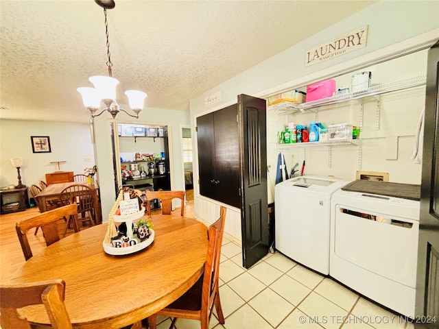 dining room with independent washer and dryer, a textured ceiling, light tile patterned floors, and an inviting chandelier