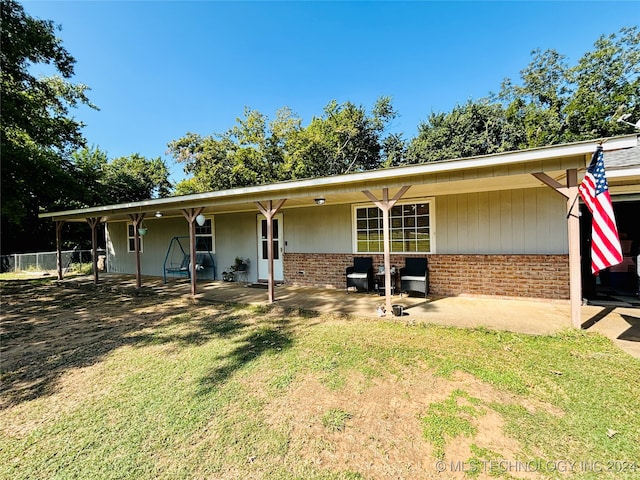 back of property featuring a lawn and a patio area