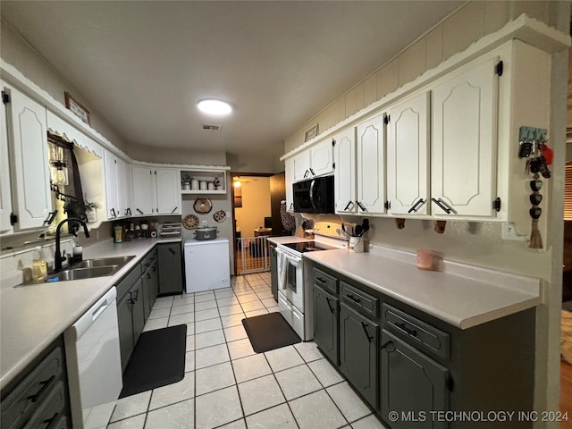 kitchen with electric range, sink, white dishwasher, washer / dryer, and white cabinets