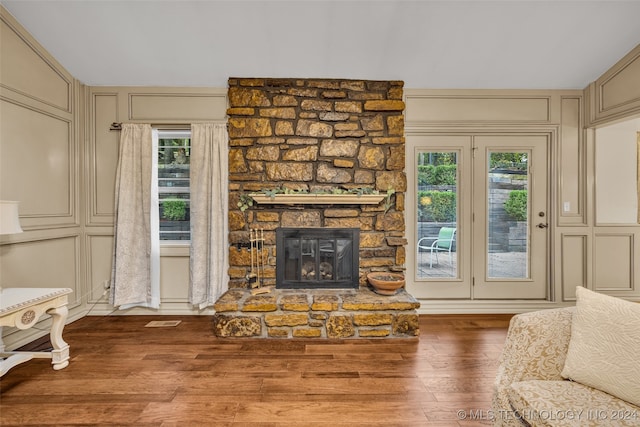 living room featuring a stone fireplace and hardwood / wood-style flooring