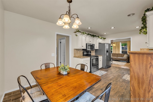 dining space with a chandelier and dark hardwood / wood-style flooring