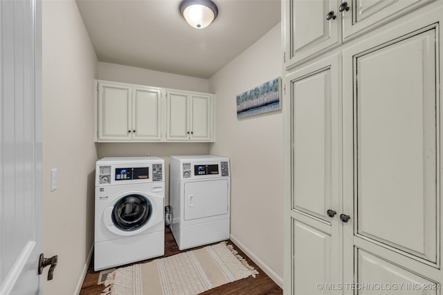 laundry room with cabinets, washer and dryer, and dark wood-type flooring