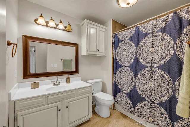 bathroom with toilet, walk in shower, and vanity