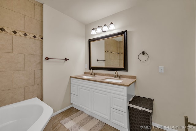 bathroom with vanity, hardwood / wood-style floors, and a tub