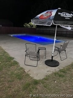 view of pool at twilight