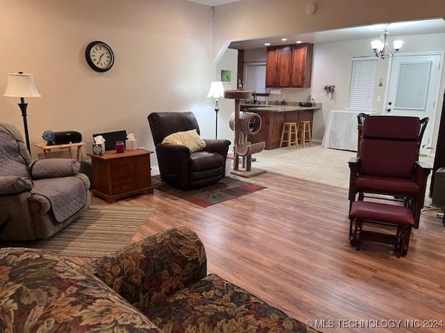 living room featuring a notable chandelier and light wood-type flooring