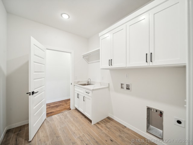 clothes washing area with cabinets, washer hookup, hookup for an electric dryer, sink, and light hardwood / wood-style flooring