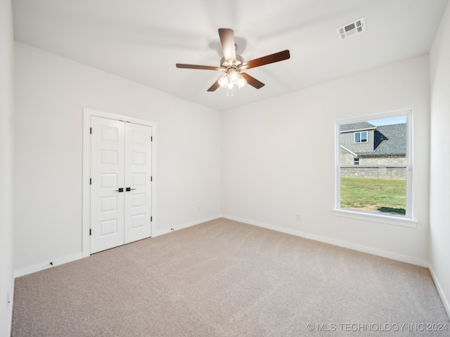 spare room featuring ceiling fan and carpet floors