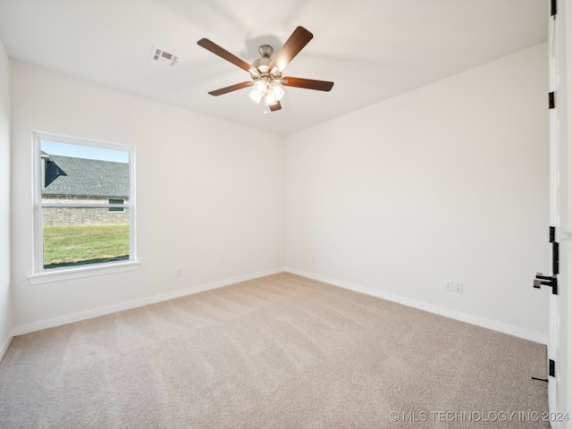 spare room featuring light colored carpet and ceiling fan