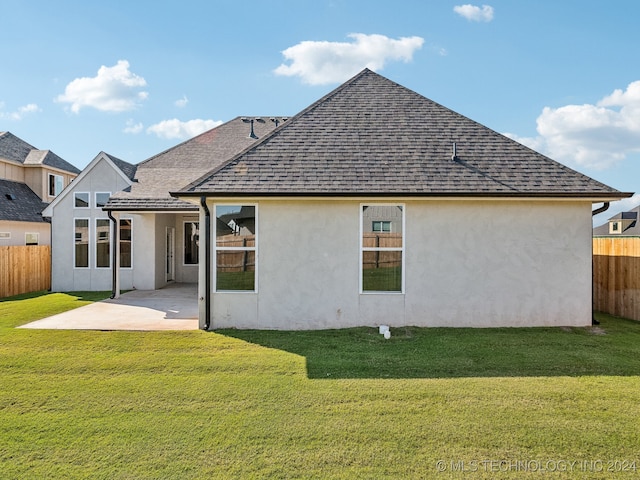 rear view of property featuring a patio and a lawn