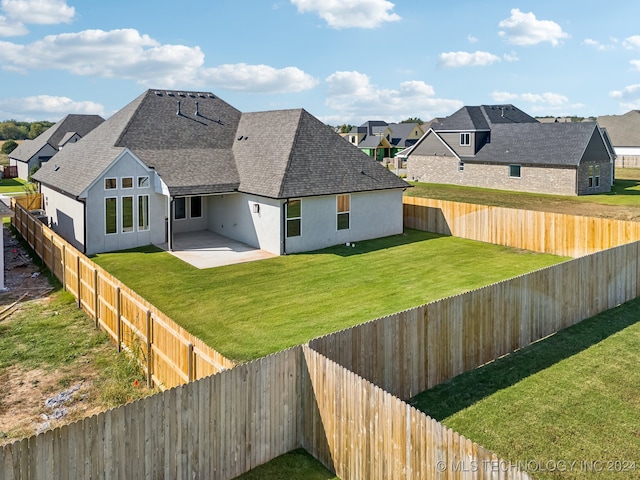 back of house with a lawn and a patio area