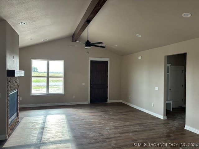 unfurnished living room with a stone fireplace, lofted ceiling with beams, dark hardwood / wood-style floors, and ceiling fan