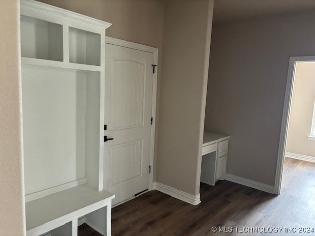 mudroom with dark wood-style floors and baseboards