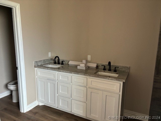 bathroom featuring toilet, vanity, and hardwood / wood-style floors