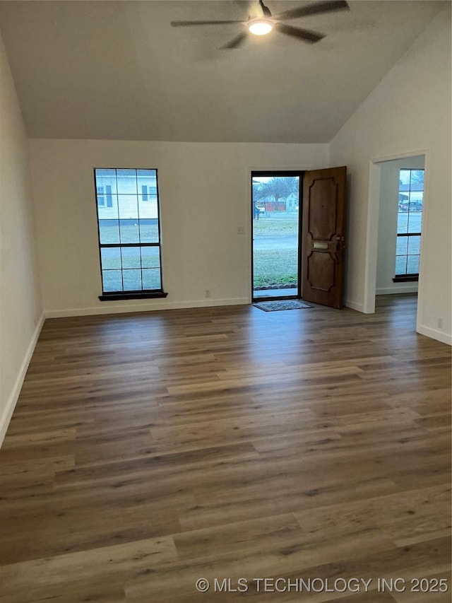 unfurnished room with lofted ceiling, plenty of natural light, a ceiling fan, and wood finished floors