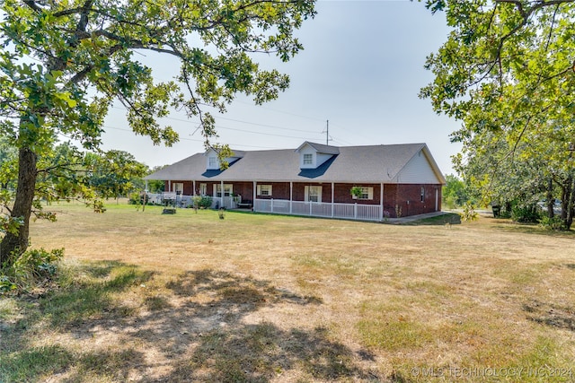 back of house with a lawn and covered porch