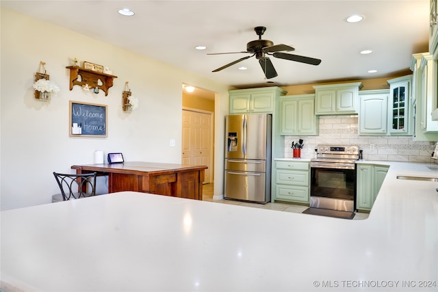 kitchen featuring ceiling fan, appliances with stainless steel finishes, tasteful backsplash, and sink