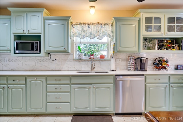 kitchen with light tile patterned flooring, sink, stainless steel appliances, and tasteful backsplash