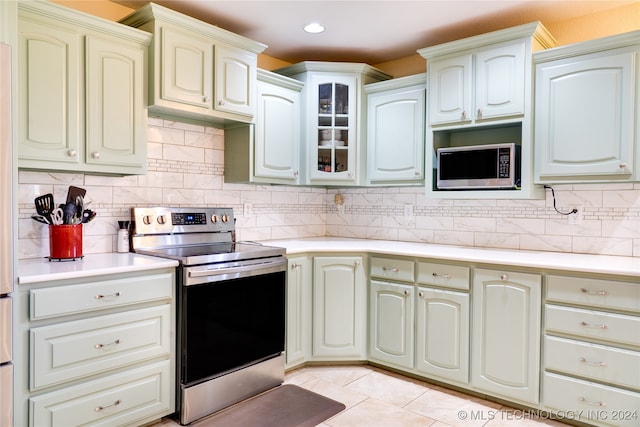 kitchen featuring backsplash, light tile patterned flooring, and stainless steel appliances