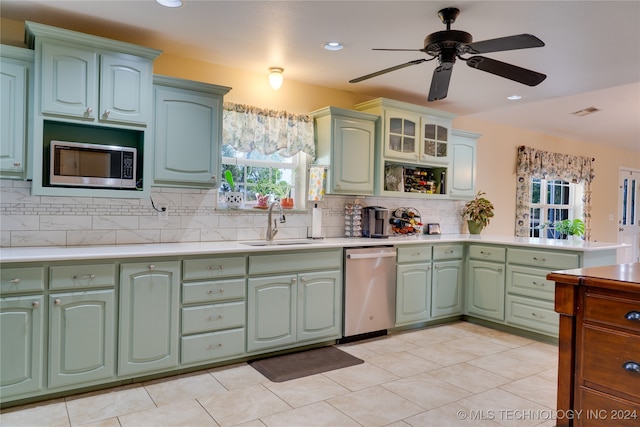 kitchen with sink, decorative backsplash, appliances with stainless steel finishes, light tile patterned floors, and ceiling fan