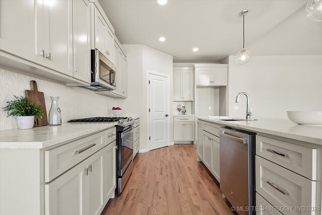 kitchen with appliances with stainless steel finishes, sink, and white cabinetry