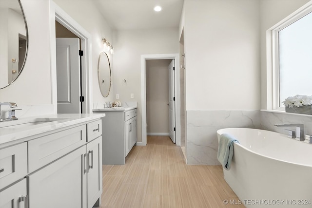 bathroom with vanity, a tub, and a wealth of natural light