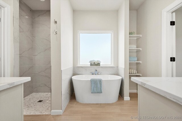 bathroom featuring wood-type flooring, independent shower and bath, and vanity