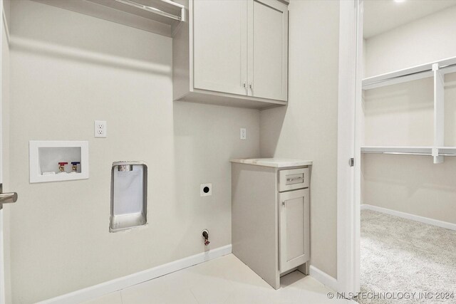 clothes washing area with hookup for a washing machine, cabinets, gas dryer hookup, and hookup for an electric dryer