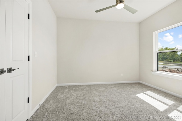 carpeted spare room with ceiling fan