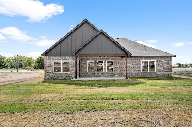 rear view of property featuring a patio and a yard