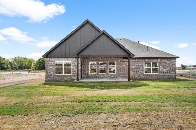 rear view of property featuring a patio and a yard